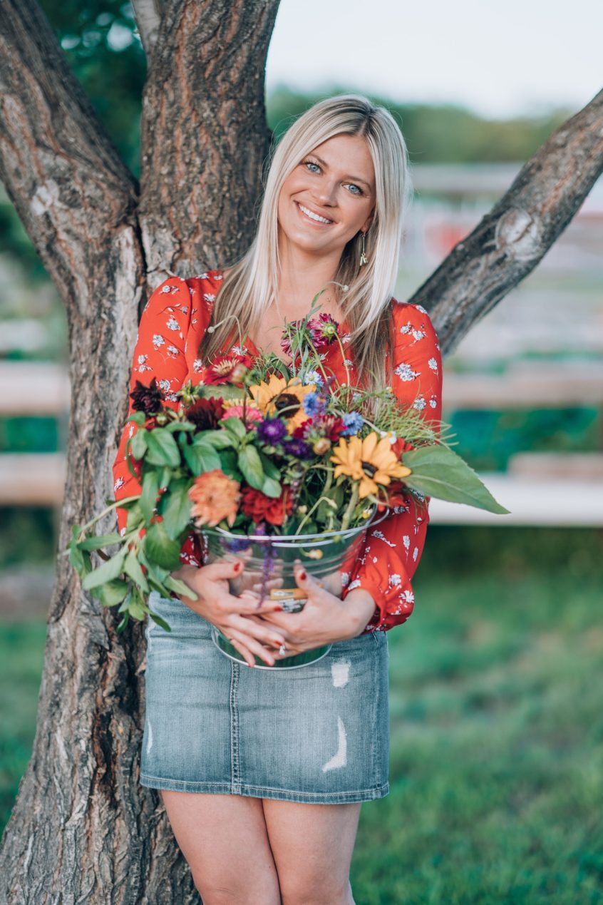 Kim Derkach holding a pail of fresh-cut flowers
