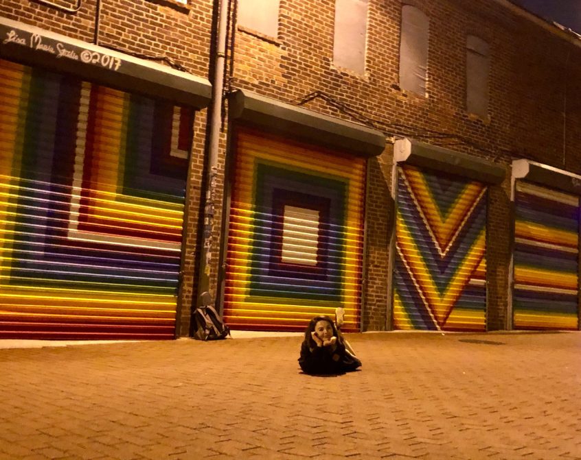 Michaela Sidloski posing in front of urban art