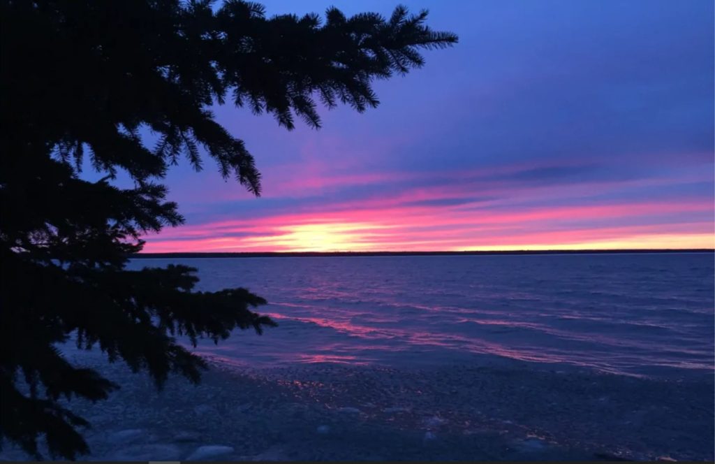 Bright pink sunset over a lake.