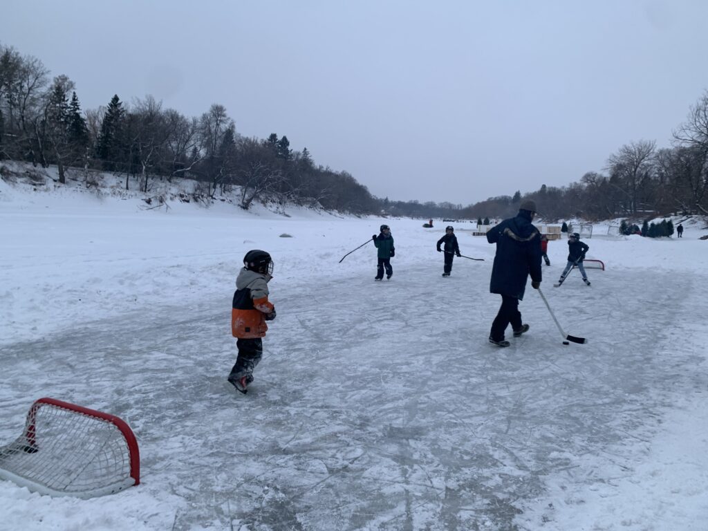Kids playing hockey on River RInk Winnipeg, MB - winter 2021. Photo by Mira Oberman